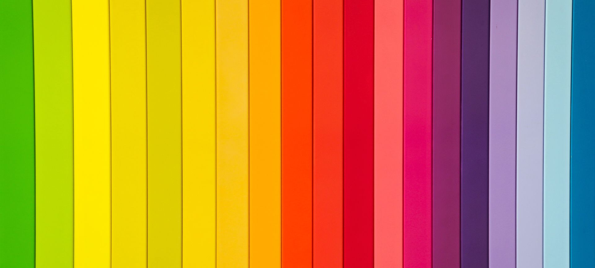 a group of rainbow colored pencils lined up in a row
