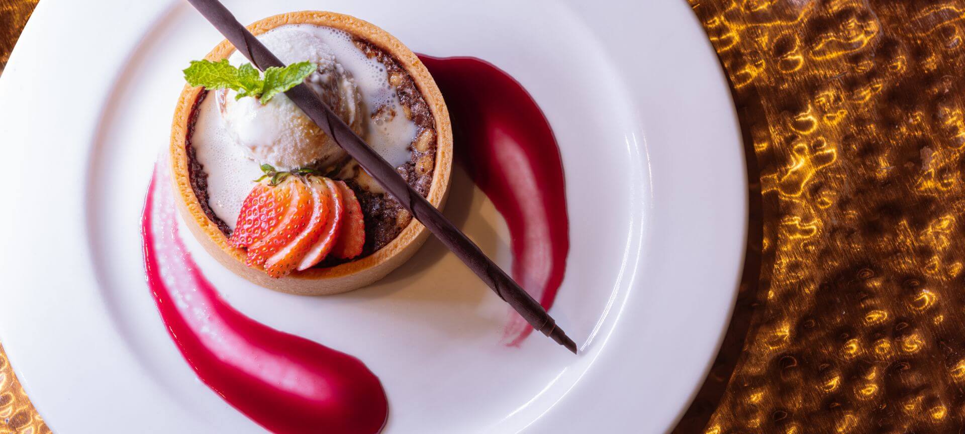 a dessert with strawberries and ice cream on a white plate