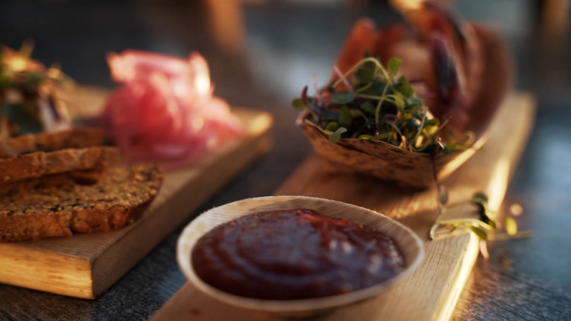 a wooden tray topped with bread and a bowl of ketchup