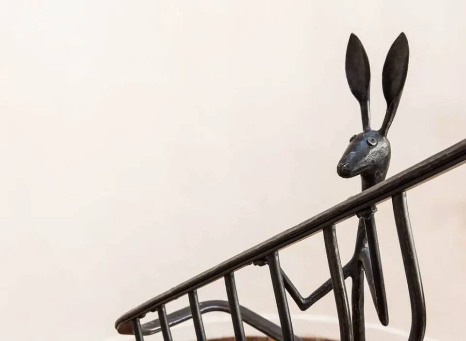 This close-up view shows a hand-forged iron jackrabbit incorporated into a black railing detail.