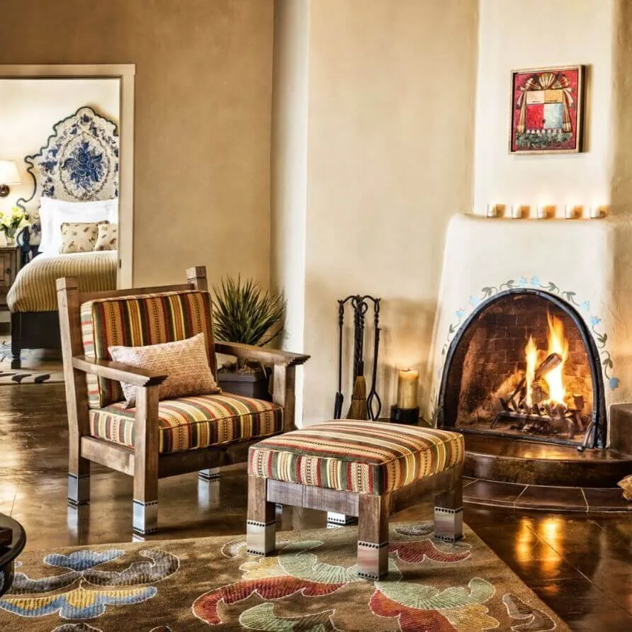 This beautiful hotel suite living room features a warm kiva fireplace and comfortable striped furniture.