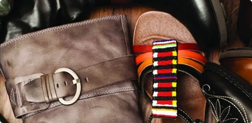 Close-up view of contrasting leather footwear details, including a buckled boot and a vibrant beaded sandal.