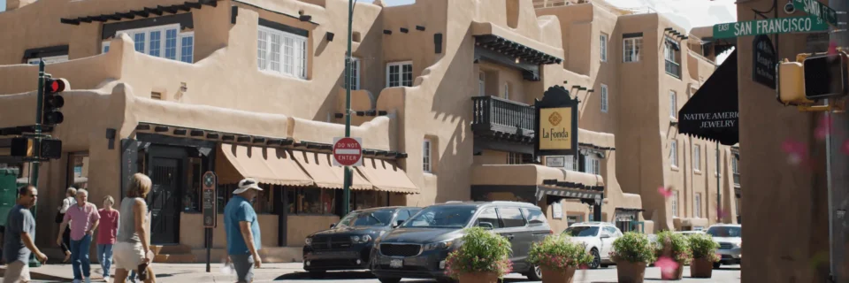 The historic Pueblo Revival exterior of this boutique hotel features balconies and street-level shops.