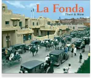 A colorized historical photograph shows vintage cars and riders passing by the famous adobe hotel structure.