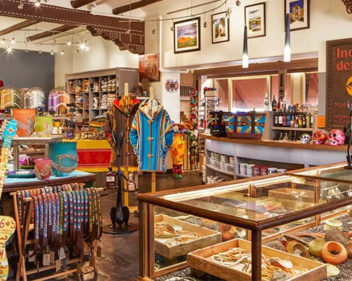 Inside the vibrant artisan goods store, display cases highlight handcrafted jewelry and colorful Southwestern apparel.