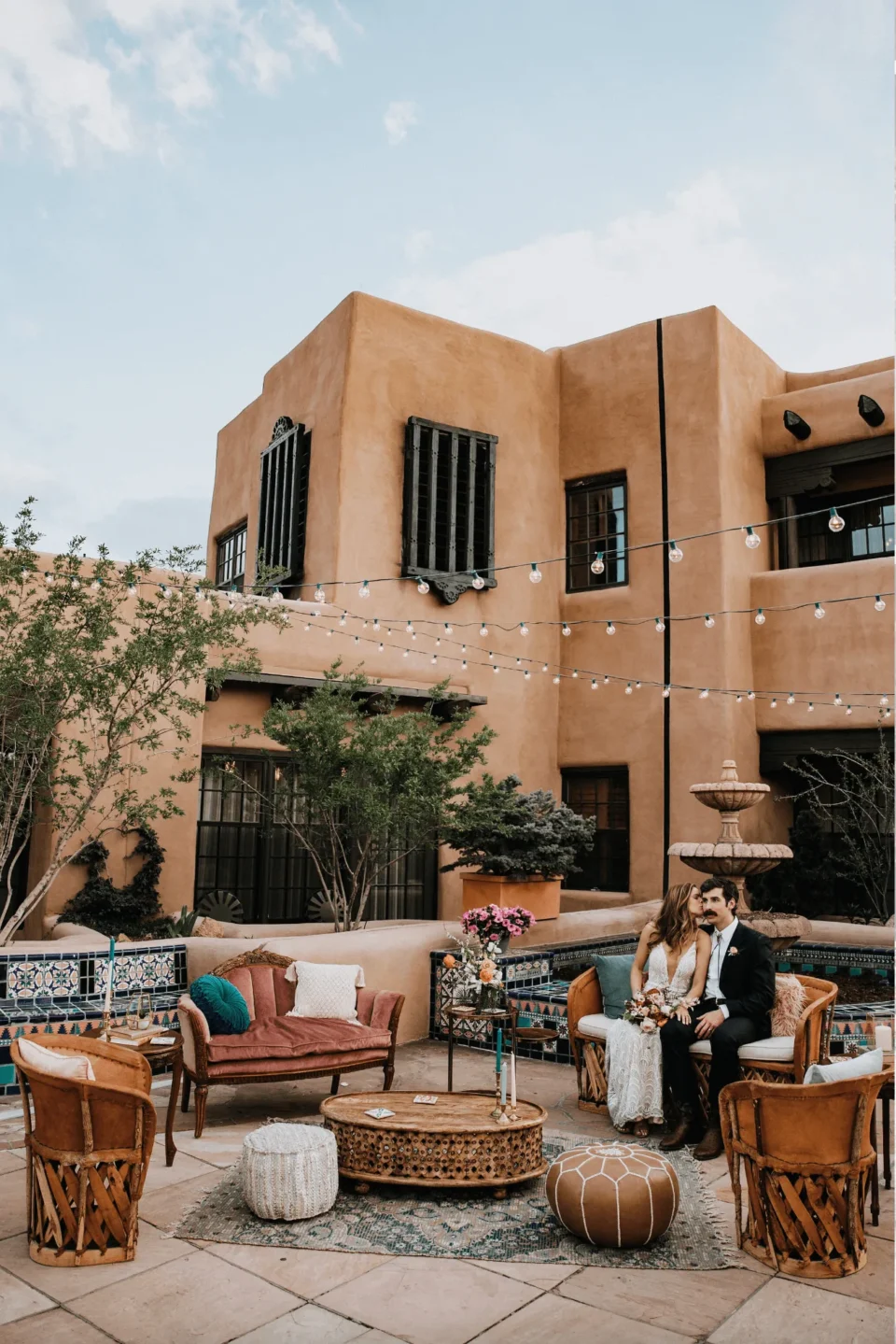 A newly married couple relaxes on a decorative courtyard patio, showcasing a premier outdoor wedding venue.