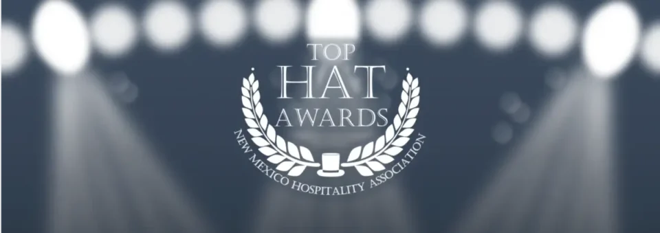 The Top Hat Awards logo graphic features white text and a laurel wreath on a dark background illuminated by bright.