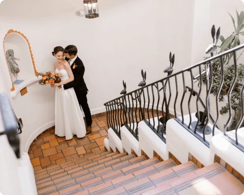 A bride and groom pose lovingly on a tiled landing, showcasing the unique event spaces in Santa Fe.