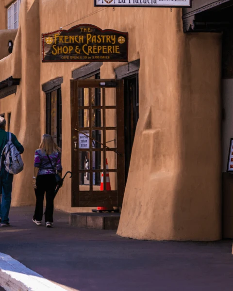 Guests approach the entrance of The French Pastry Shop and Cr锚perie in the adobe-style building.