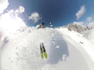 A Person Skiing Down A Snowy Hill