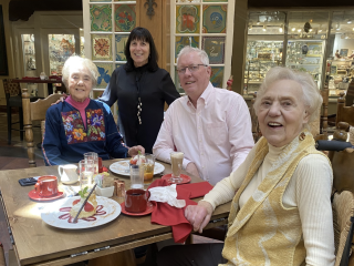 A Group Of People Sitting Around A Table With Food On It