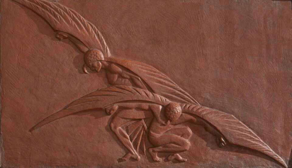 This terracotta relief sculpture depicts two muscular winged figures crouching against a reddish, textured background.
