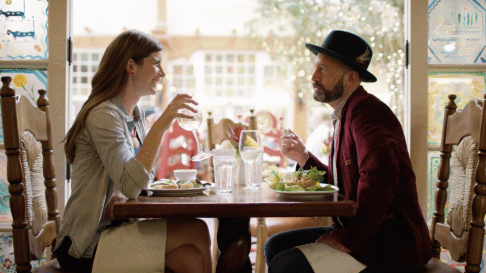 A man and a woman share a glass of wine and a meal inside one of the restaurants in Santa Fe, New Mexico.