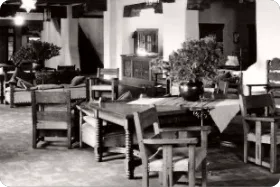 This vintage photograph shows an original event space furnished with rustic Southwestern tables and chairs.