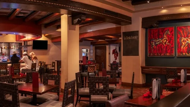 Guests enjoy drinks at the bar in the Southwestern-style downtown Santa Fe restaurant lounge.