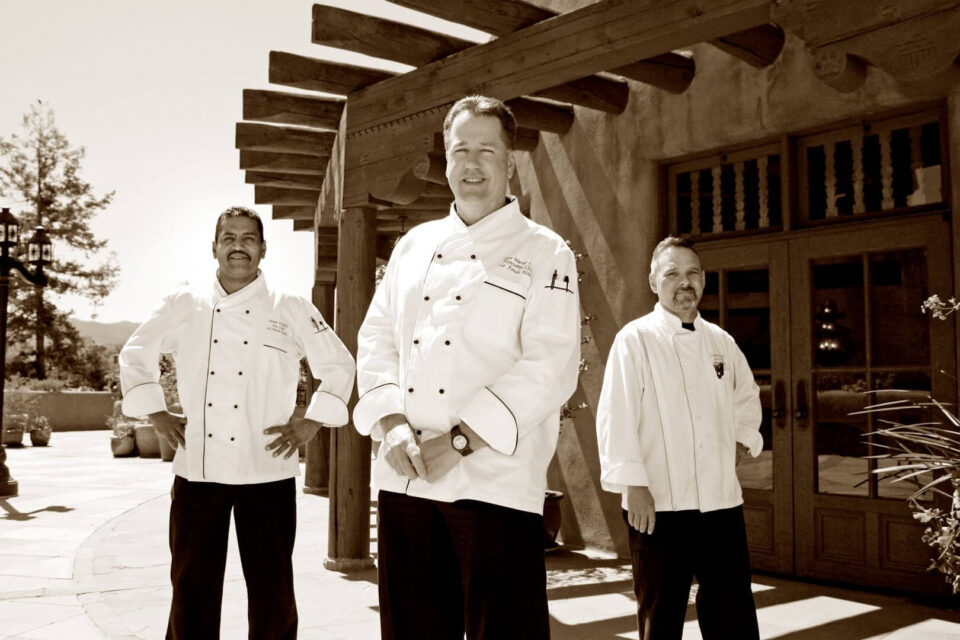 The professional culinary team stands on the exterior patio of the downtown Santa Fe restaurant.