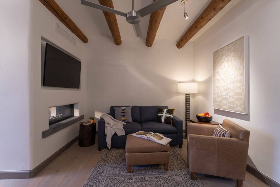 The luxurious hotel suites offer a comfortable sitting area with a modern fireplace and southwestern decor.