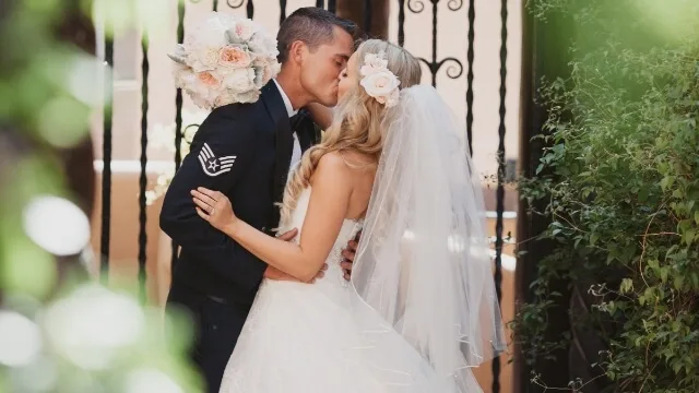 The happy bride and groom kiss passionately following their beautiful ceremony at a premier wedding venue.