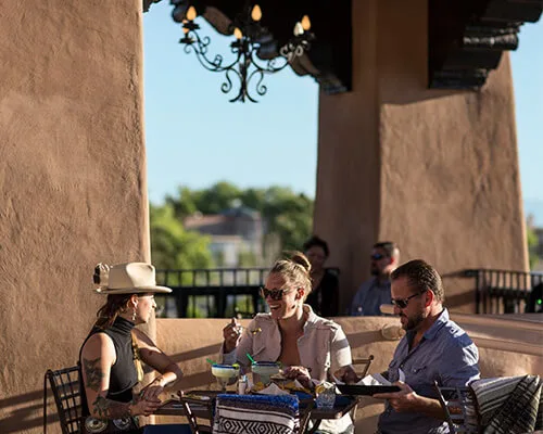Guests enjoy drinks and appetizers at the popular rooftop bar overlooking the cityscape.