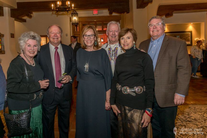 A group of smiling guests enjoying a cocktail reception in the elegant hotel event space.