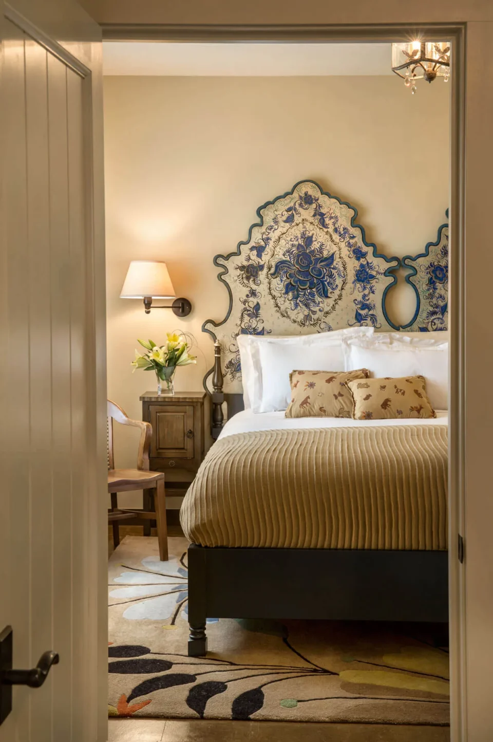 This beautiful boutique hotel room features a unique blue and white painted headboard and cozy textiles.