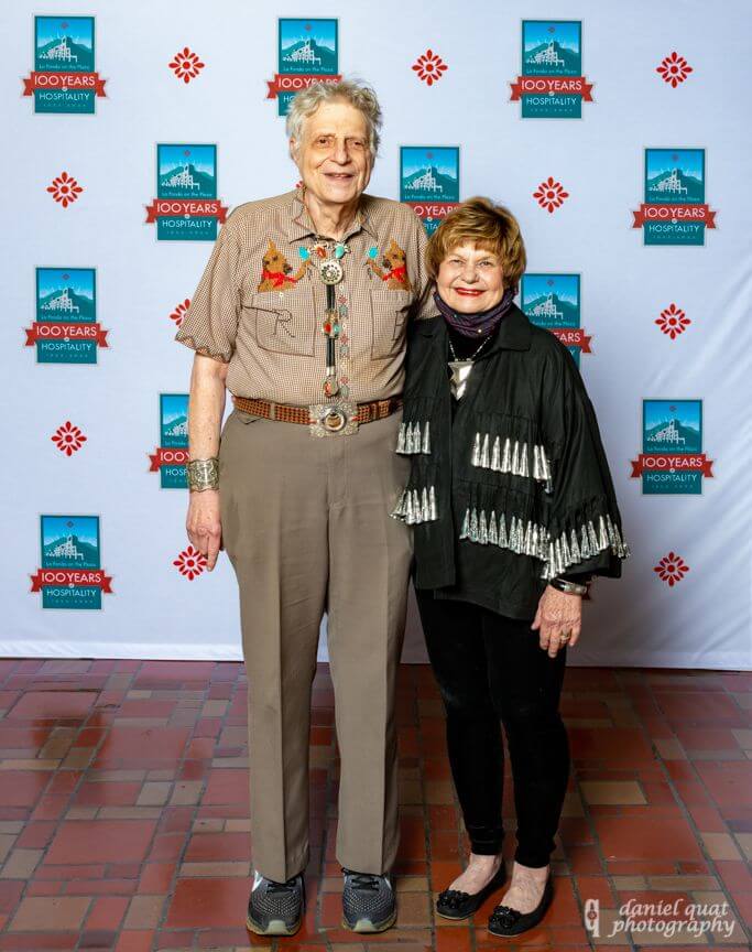 Guests in Western dress smiling while standing in a banquet hall.