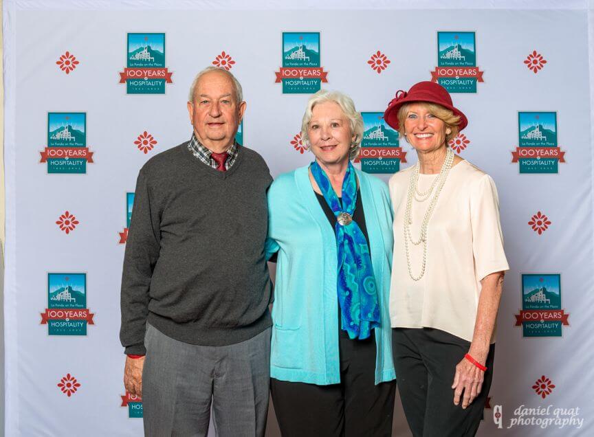 Smiling guests stand together for a photo opportunity at the grand hotel event space.