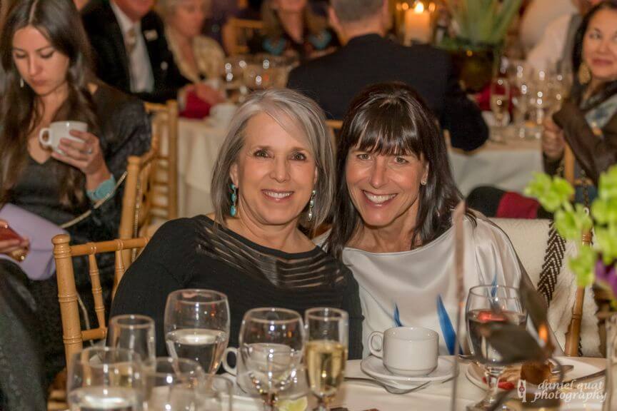Smiling guests enjoy dinner in the beautifully decorated banquet hall.
