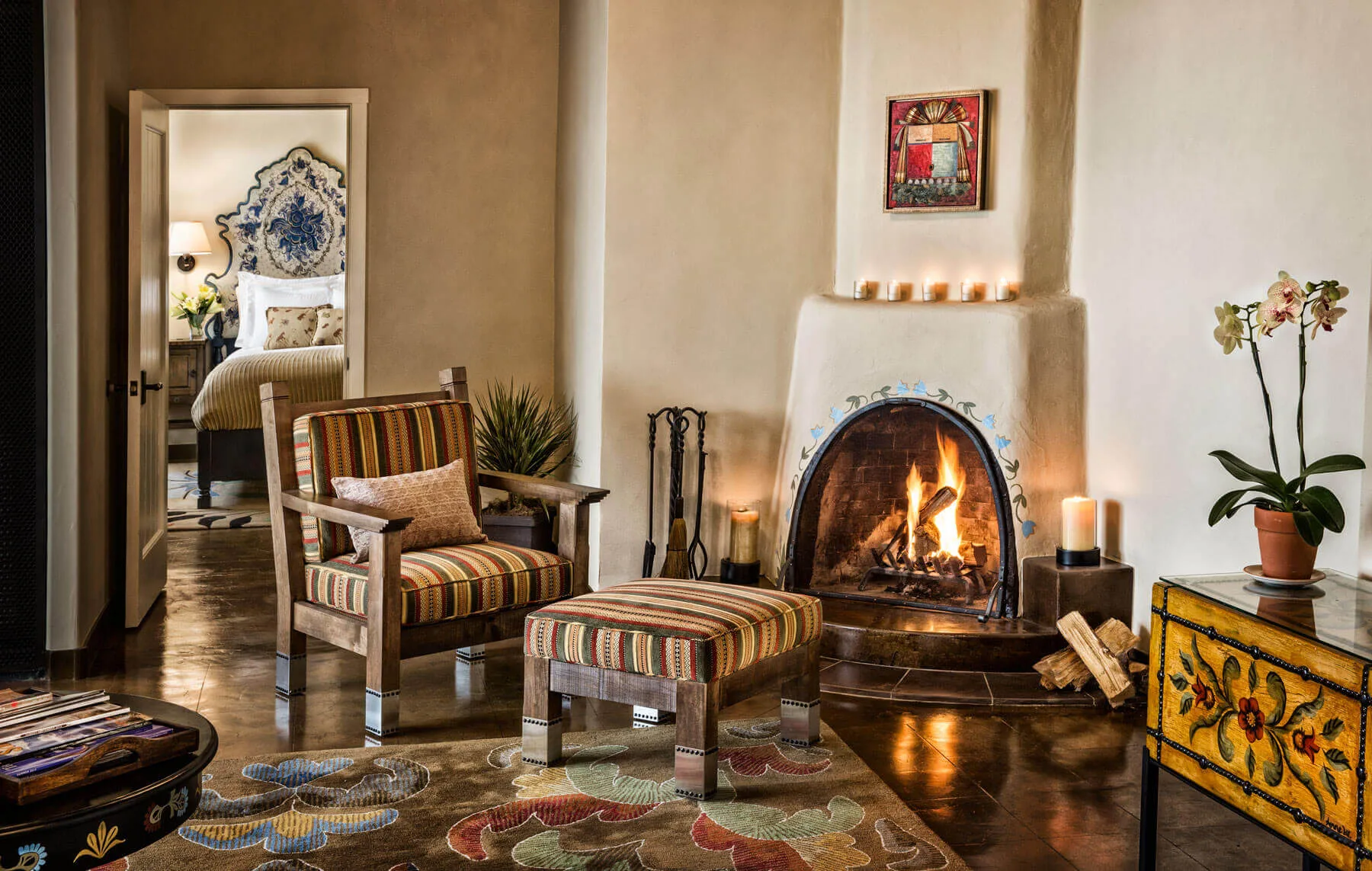 A luxurious seating area in one of our hotel suites features a lit adobe fireplace and southwestern decor.