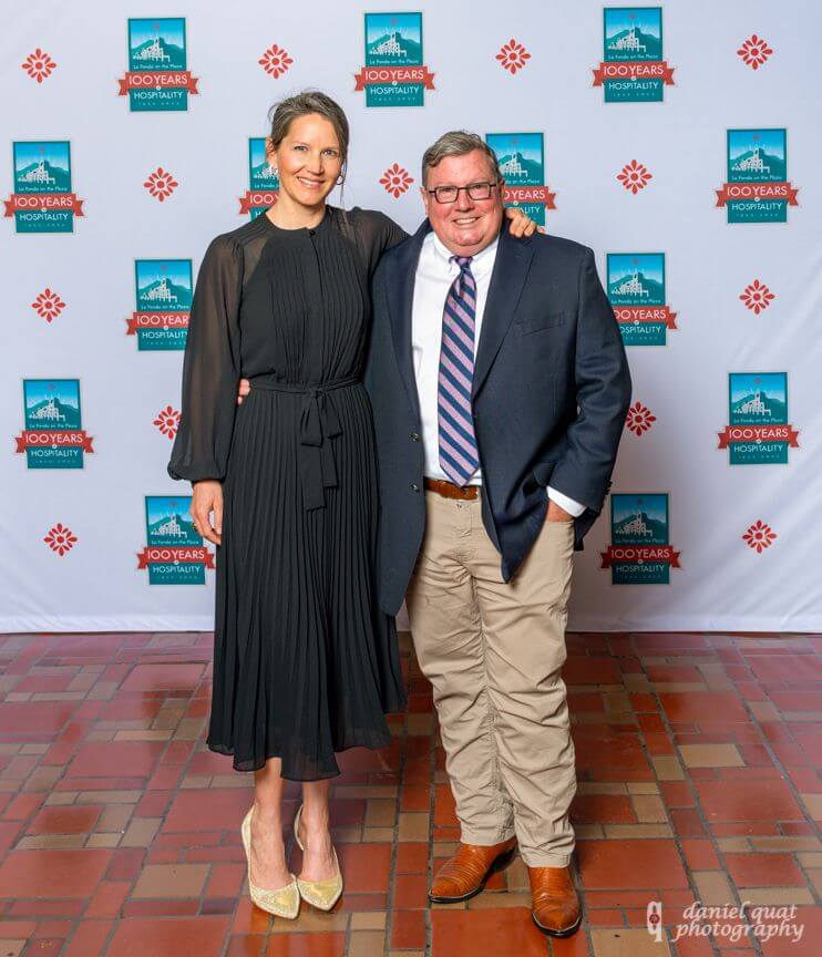 Two smiling guests pose against a branded backdrop at a celebratory reception held in the hotel's event spaces.