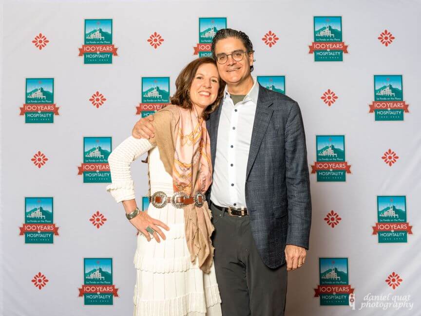 A smiling couple poses for a photograph at the La Fonda centennial celebration.