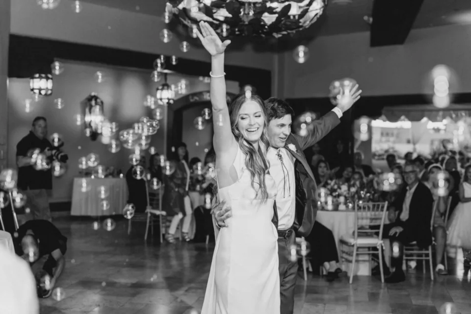 The happy couple celebrates their wedding with a lively dance surrounded by bubbles in the hotel ballroom.