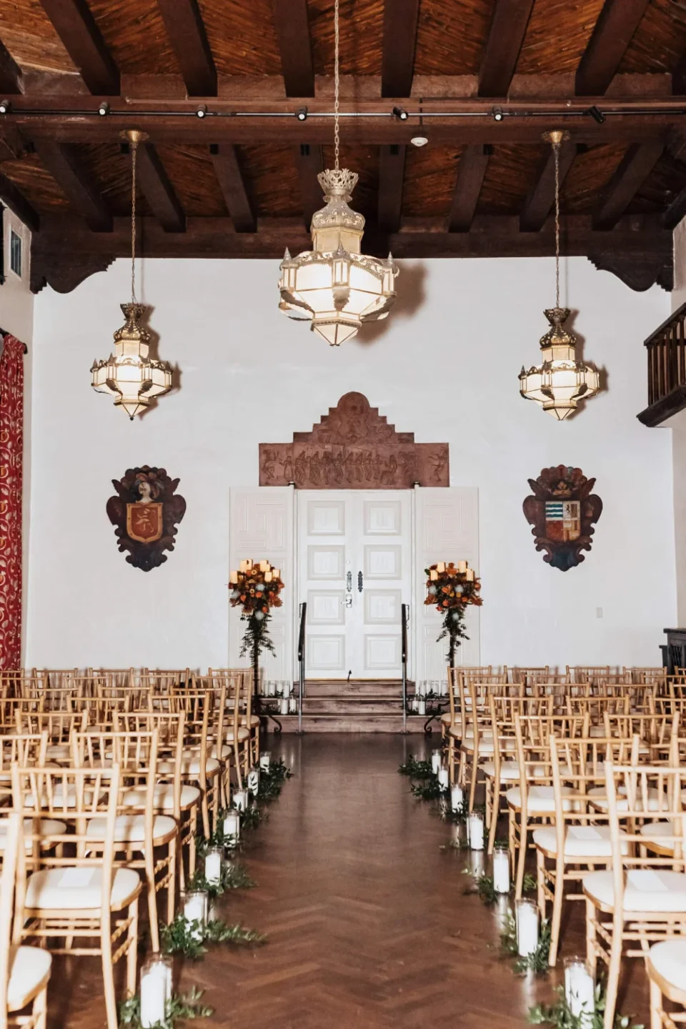 The elegant ballroom is prepared as a wedding ceremony venue with rows of chivari chairs.