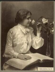 Helen Keller sniffing a rose.