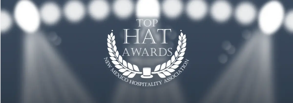 The Top Hat Awards logo graphic features white text and a laurel wreath on a dark background illuminated by bright.