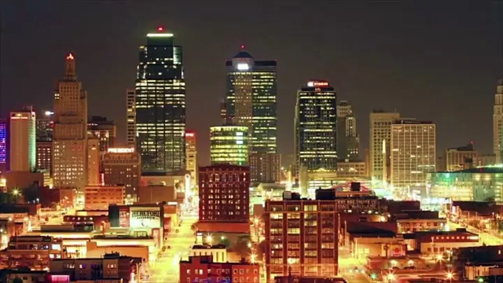 The vibrant downtown skyline is illuminated with golden light against the dark night sky.
