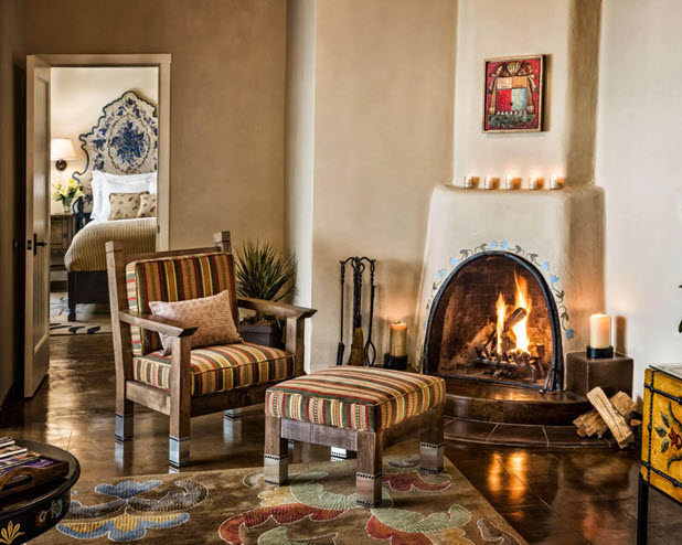 A luxurious seating area in one of our hotel suites features a lit adobe fireplace and southwestern decor.