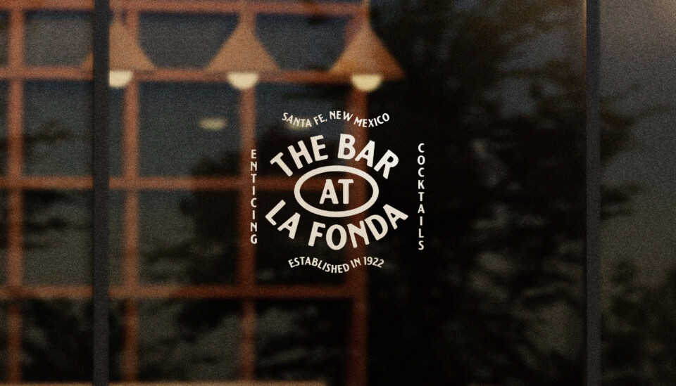 The Bar at La Fonda logo on a glass window.